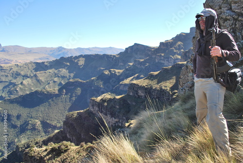 Wanderer mit AK-47 geniesst die Aussicht in Simien Bergen photo