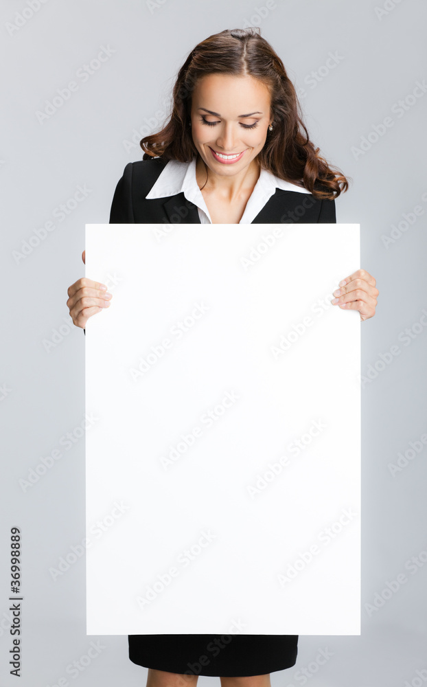 Businesswoman showing signboard, over grey Businesswoman showing signboard, over grey