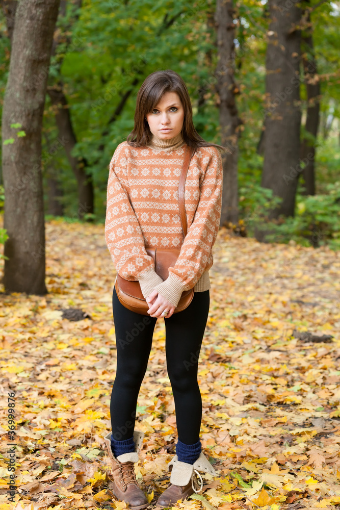 Young girl with handbag standing in the forest Young girl with handbag standing in the forest