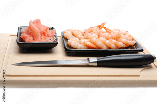 fresh shrimps and ingver on wooden board isolated. sushi ingredi