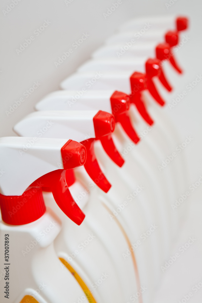 Close up of red heads of spray bottles Close up of red heads of spray bottles