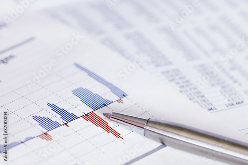 Financial planning with stock chart and pen.