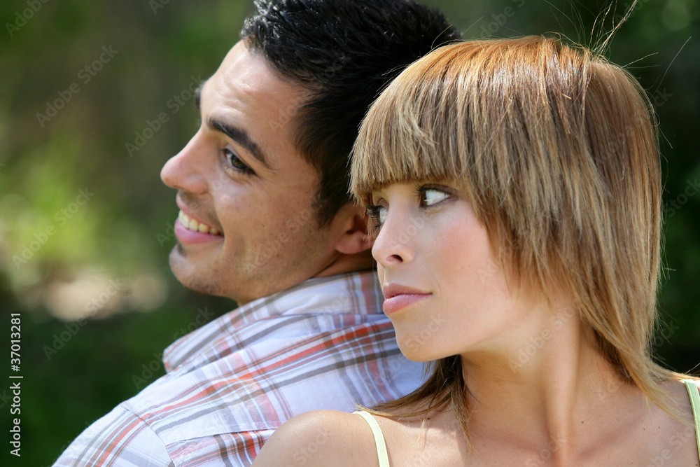 Couple stood back to back in field Couple stood back to back in field