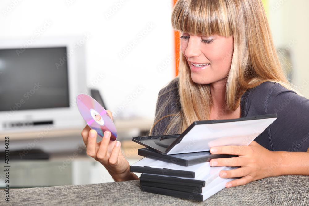 Teenage girl choosing DVD to watch Teenage girl choosing DVD to watch