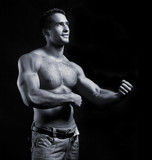 young muscular man on black background