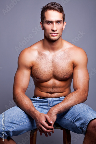 muscular man sitting on a chair photo
