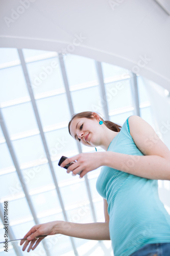 Pretty, young woman using her mobile phone/speaking on the phone