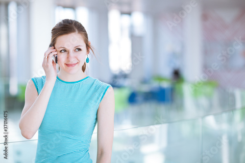 Pretty, young woman using her mobile phone/speaking on the phone