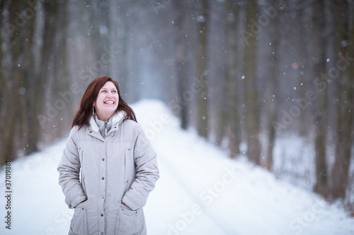 Enjoying the first snow: young woman outdoors on a lovely forest