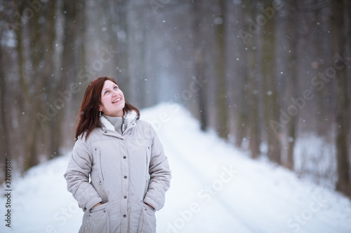 Enjoying the first snow: young woman outdoors on a lovely forest