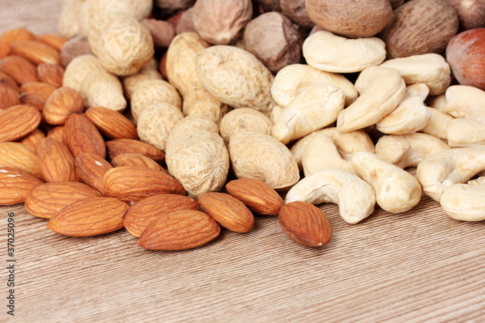 nutmeg, peanuts, hazelnuts and almonds on wooden background nutmeg, peanuts, hazelnuts and almonds on wooden background