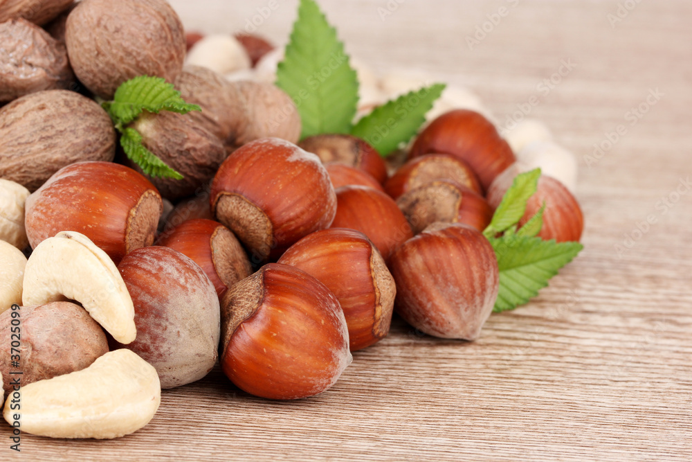 nutmeg, peanuts and almonds on wooden background nutmeg, peanuts and almonds on wooden background