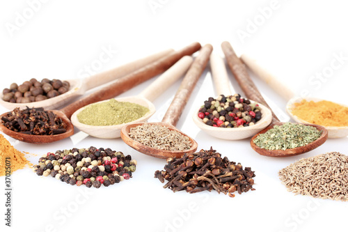 spices in the spoons isolated on white