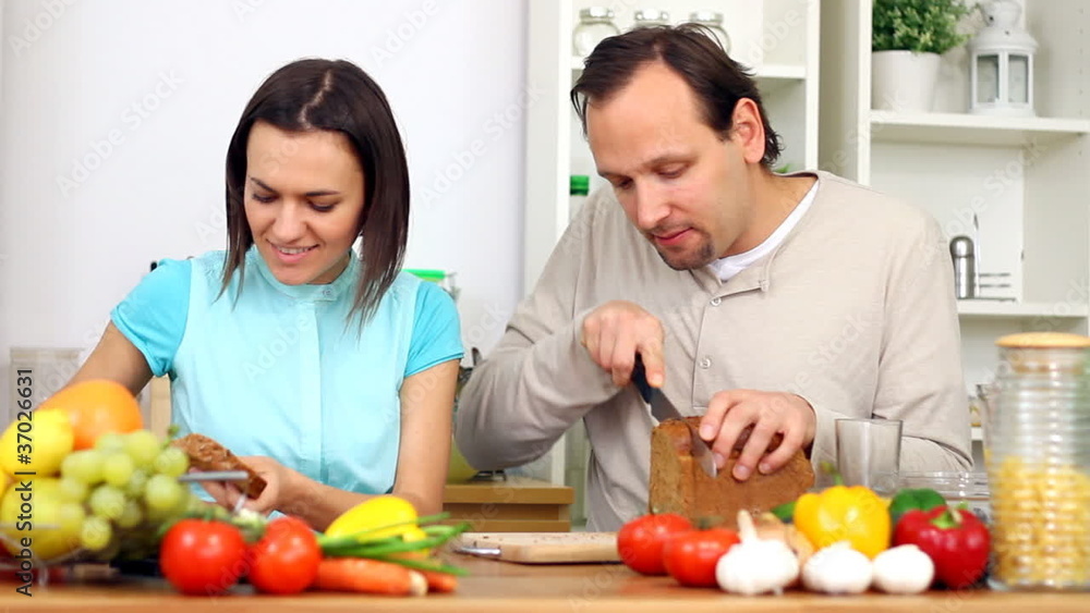 Young happy couple preparing breakfast in kitchen Young happy couple preparing breakfast in kitchen