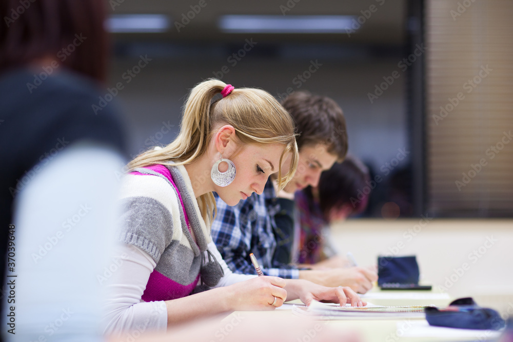 pretty female college student sitting in a classroom pretty female college student sitting in a classroom