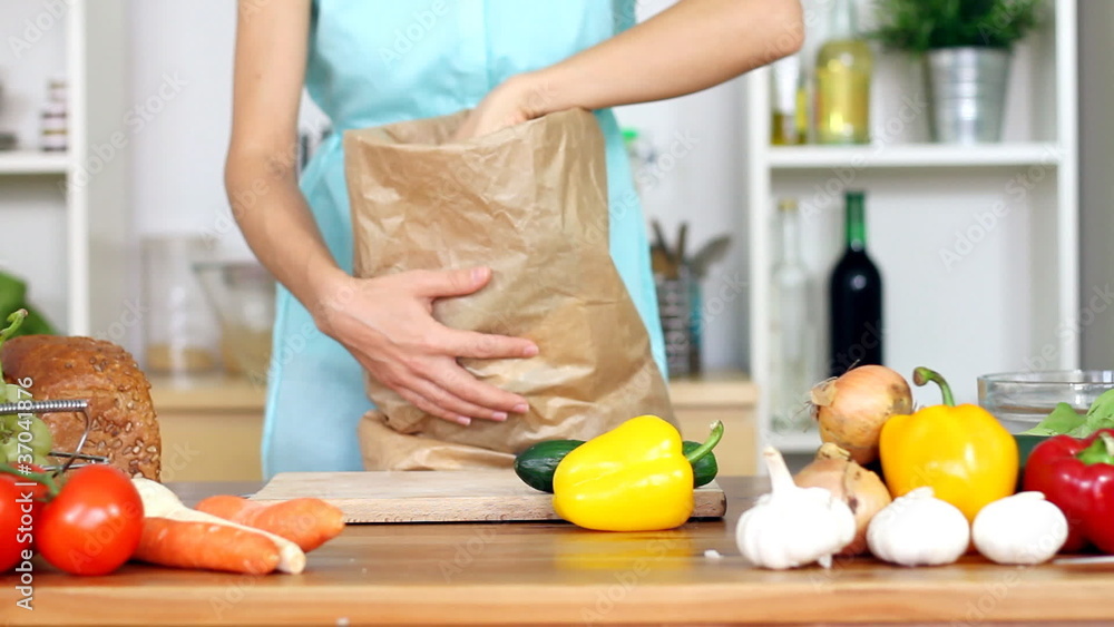Female hands unpacking vegetable groceries from paper bag Female hands unpacking vegetable groceries from paper bag