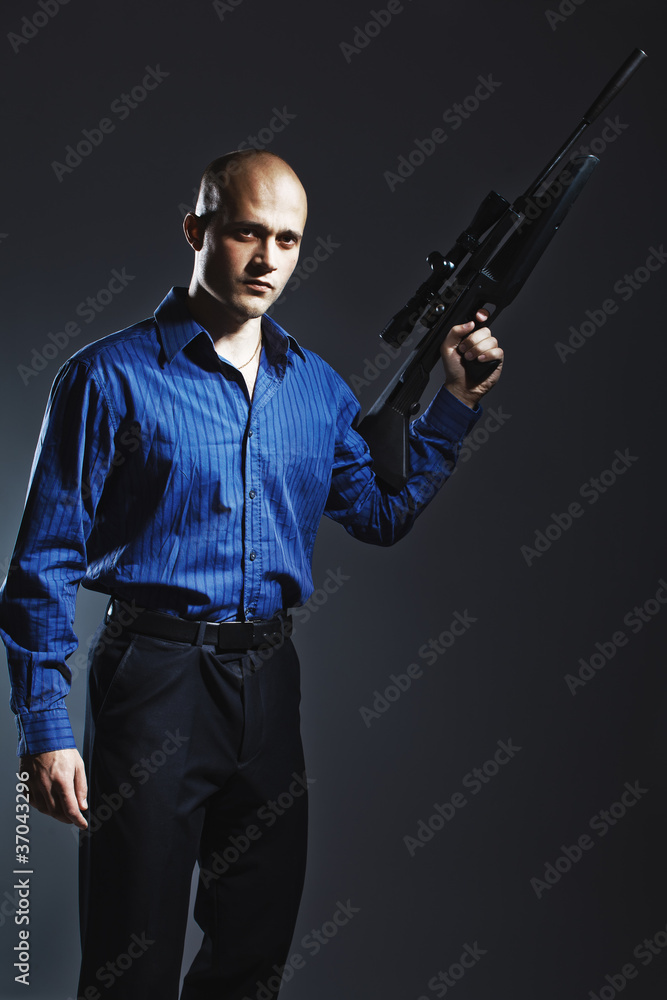 Portrait of a handsome young man holding a gun.
