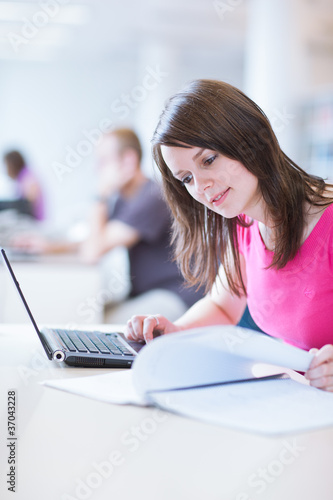in the library - pretty female student with laptop