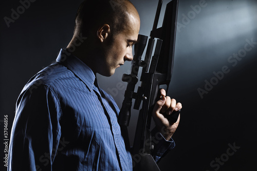 Portrait of a handsome young man holding a gun. photo