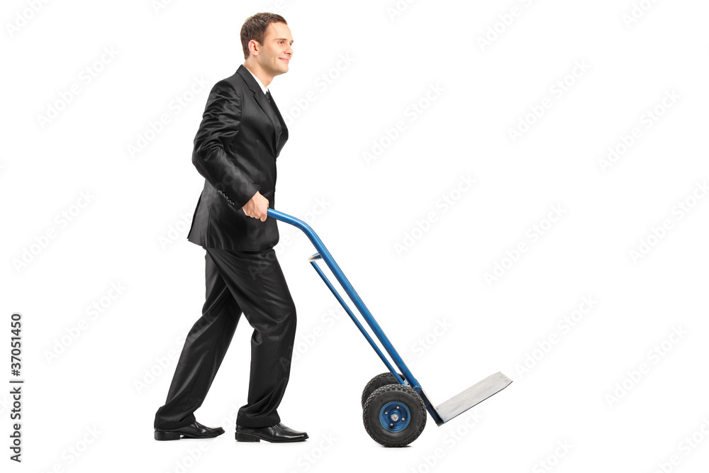 Smiling businessman pushing an empty handtruck Smiling businessman pushing an empty handtruck