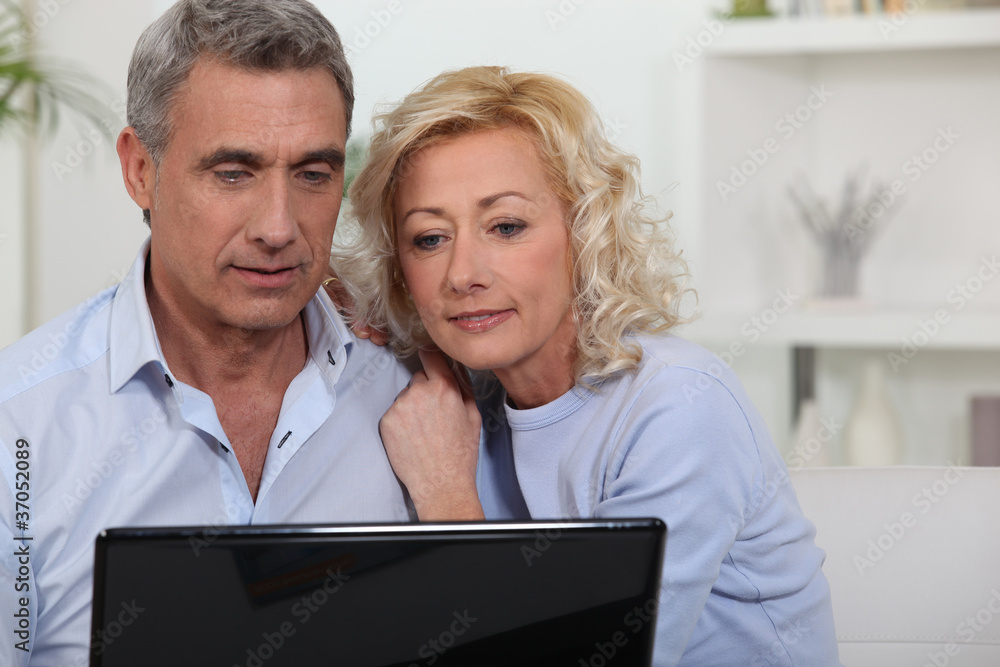 Couple looking at photos on their laptop Couple looking at photos on their laptop