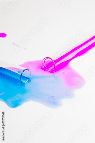 test tubes with colorful substances spilled on a white table
