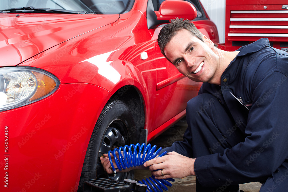 Auto mechanic changing a tire. Auto mechanic changing a tire.