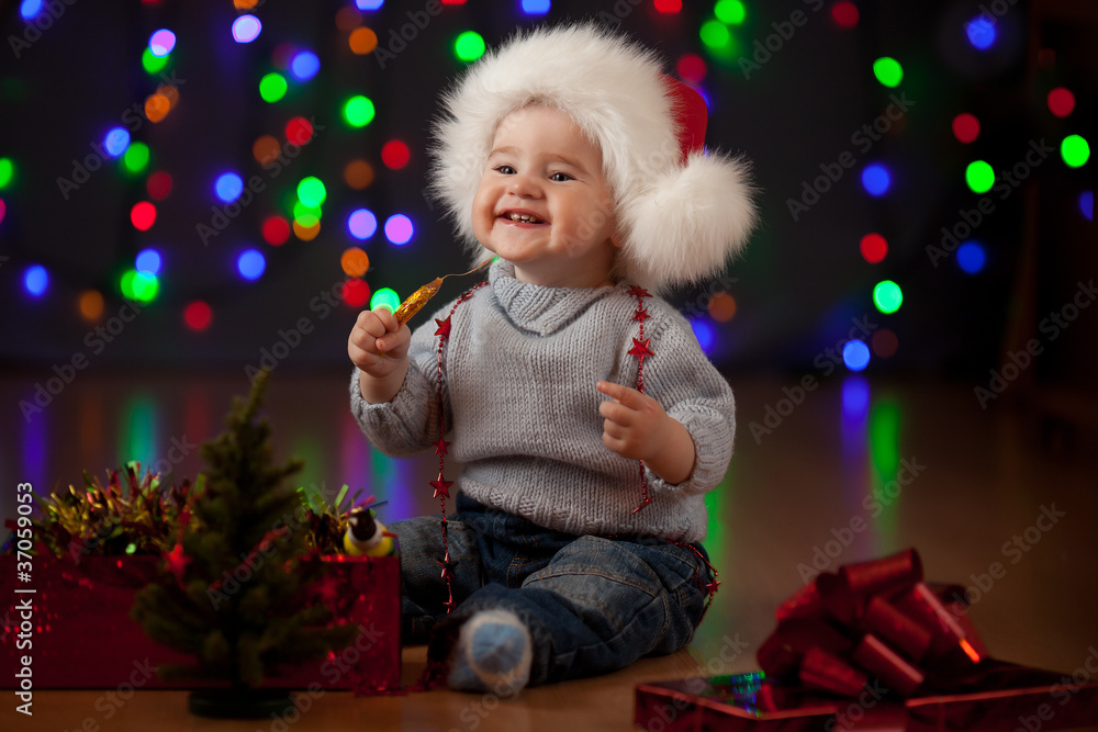 funny baby in Santa Claus hat on bright festive background