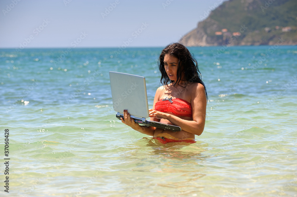 Woman at the beach with a laptop