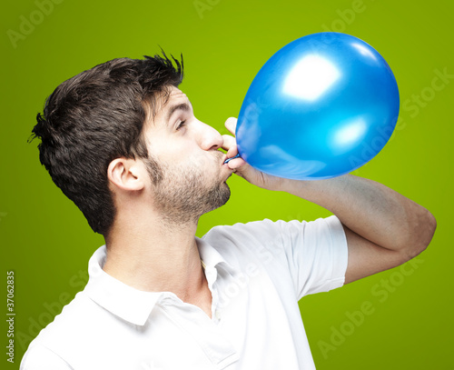 man blowing balloon