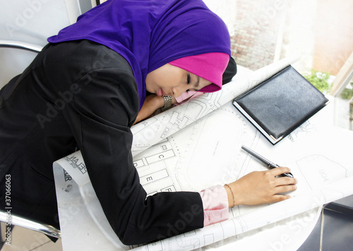 Tired young architect woman sleeping