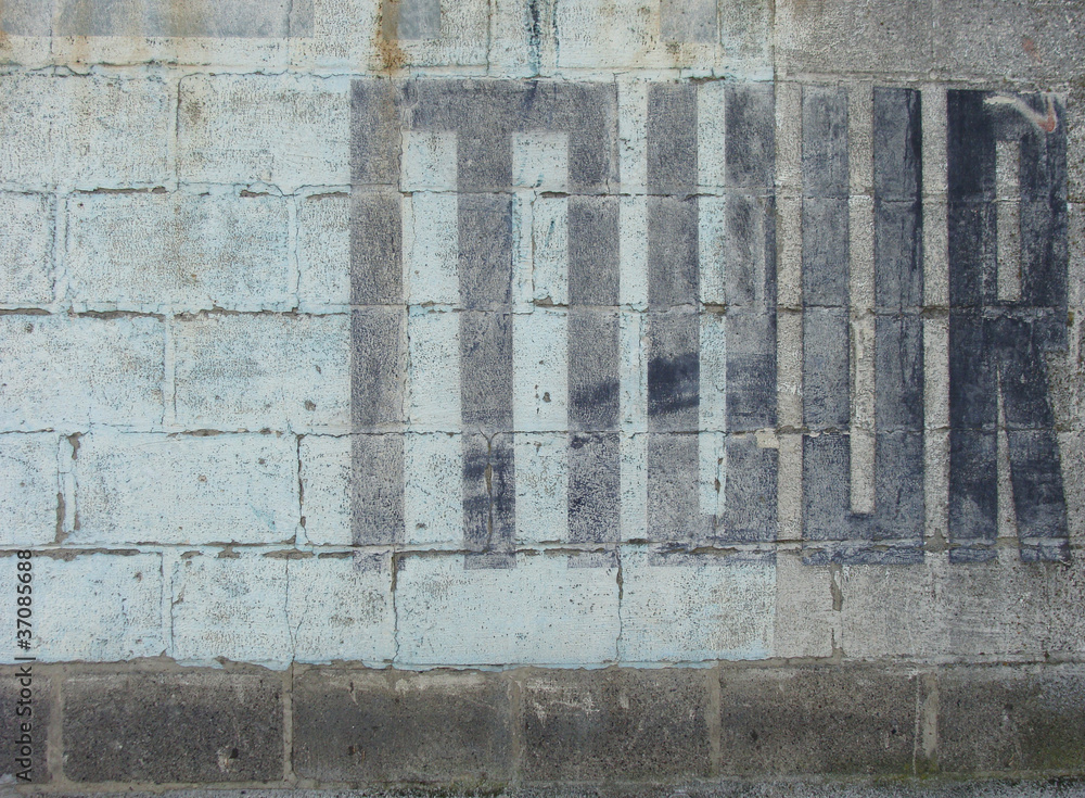 the word muur , meaning wall in dutch painted in black the word muur , meaning wall in dutch painted in black