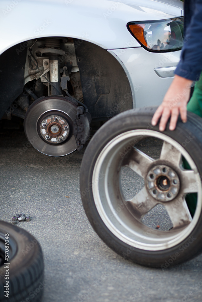 mechanic changing a wheel of a modern car mechanic changing a wheel of a modern car