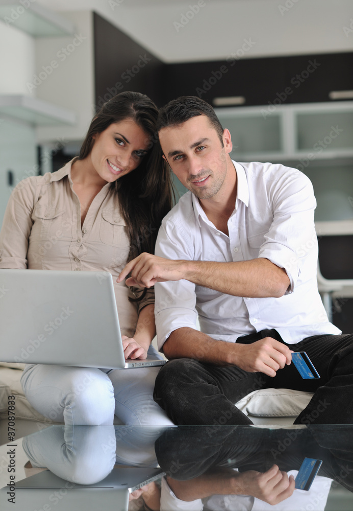 joyful couple relax and work on laptop computer at modern home joyful couple relax and work on laptop computer at modern home