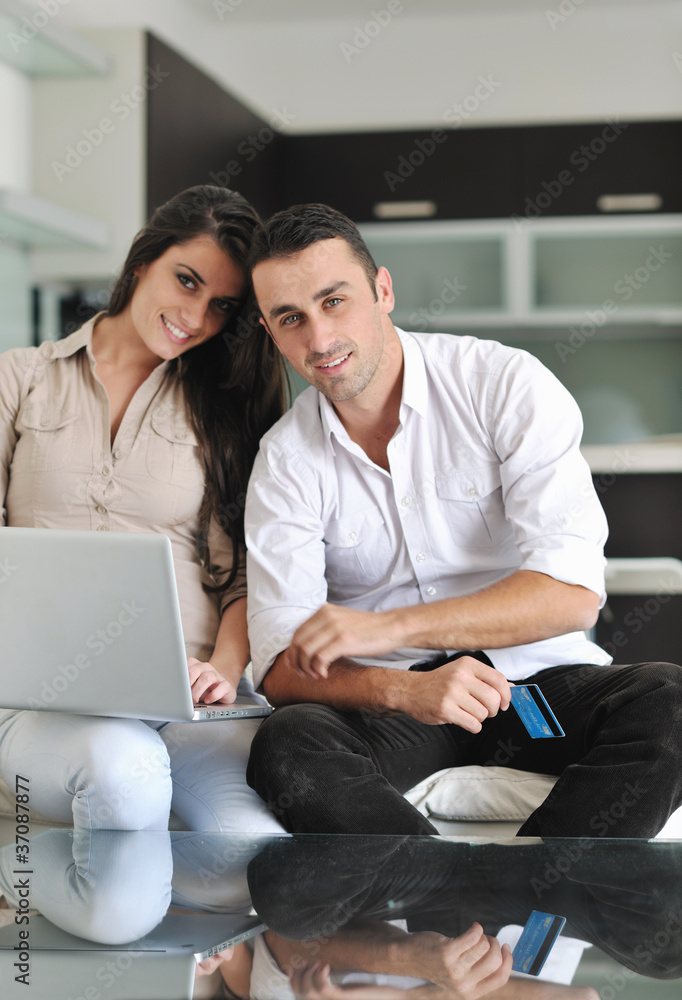 joyful couple relax and work on laptop computer at modern home joyful couple relax and work on laptop computer at modern home