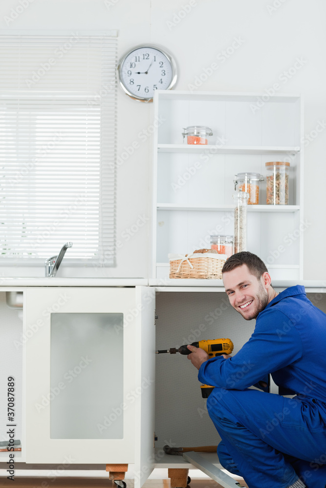 Portrait of a smiling handyman fixing a door