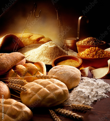 Fotografie tavolo della cucina con pane  farina e spighe di grano