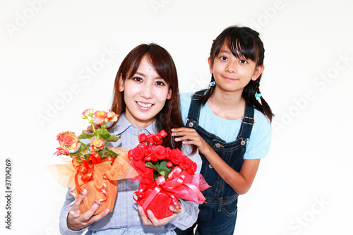 プレゼントのお花を持ち微笑む親子