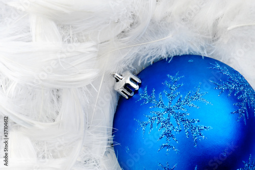 Blue Christmas bauble on white feathers
