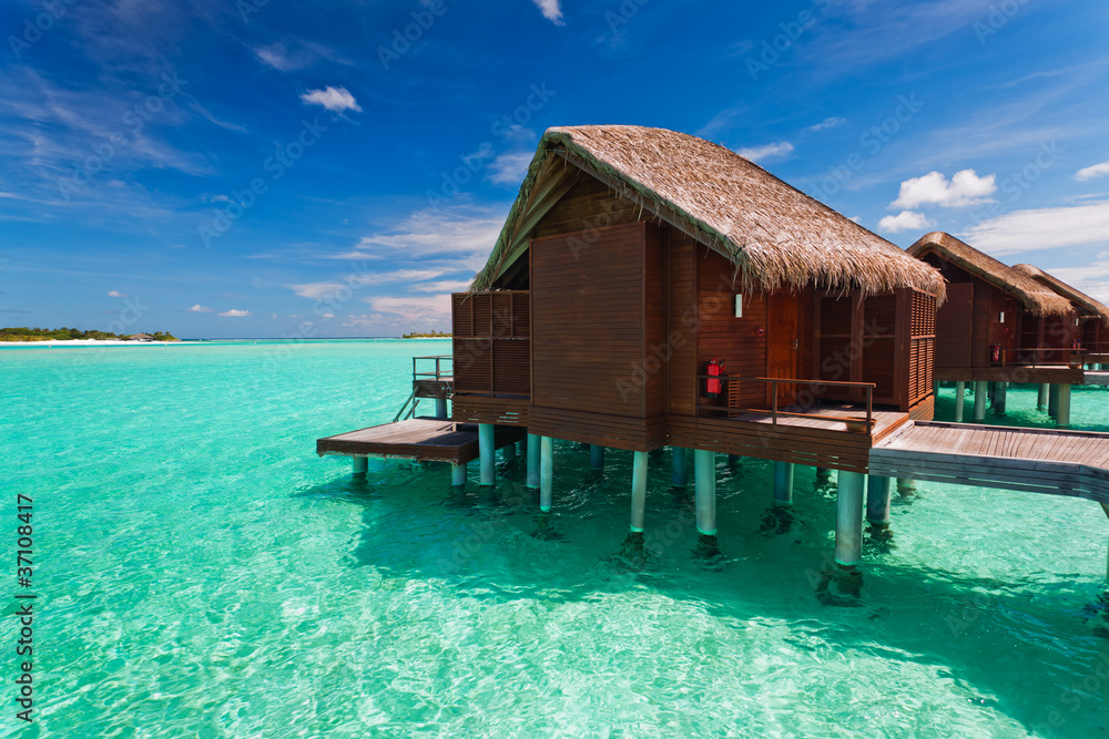 Over water bungalow with steps into tropical lagoon