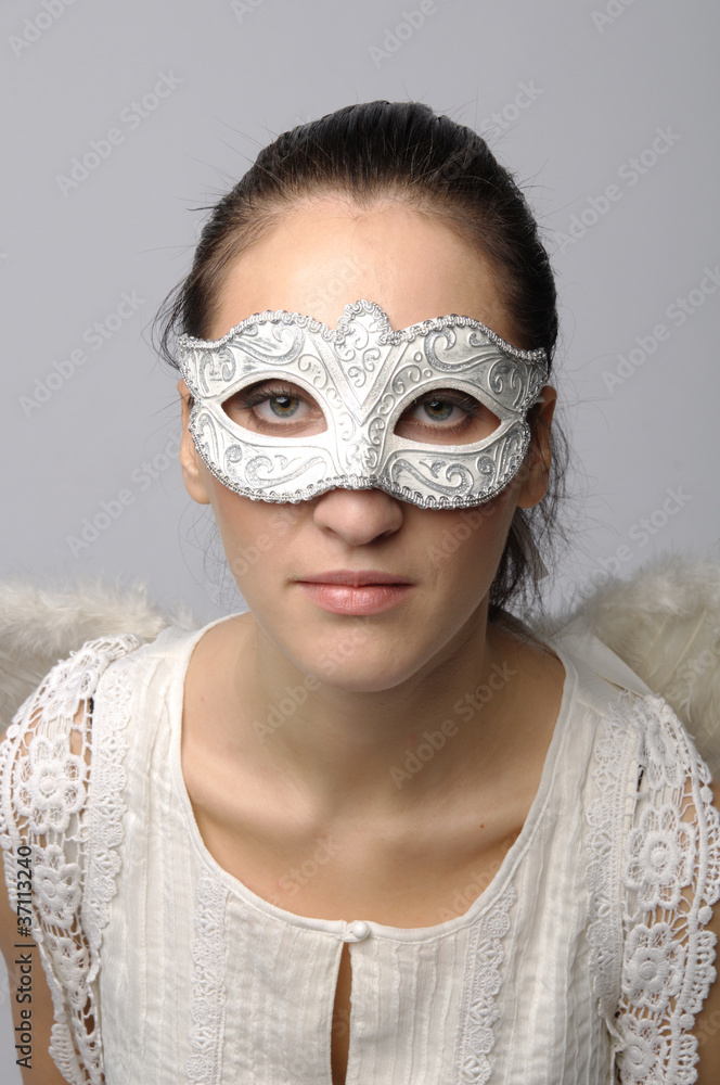 Young and beautiful girl in the mask and costume of an angel