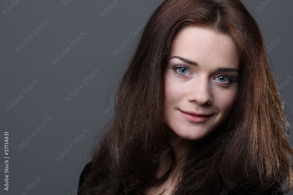 Beautiful young woman in grey background Beautiful young woman in grey background