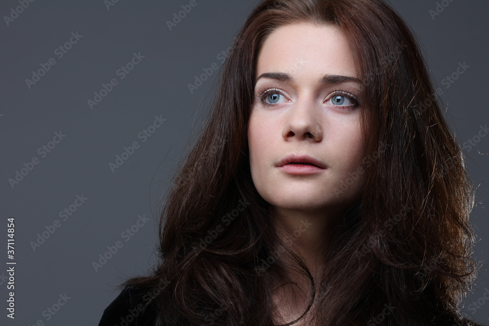Fototapeta premium Beautiful young woman in grey background