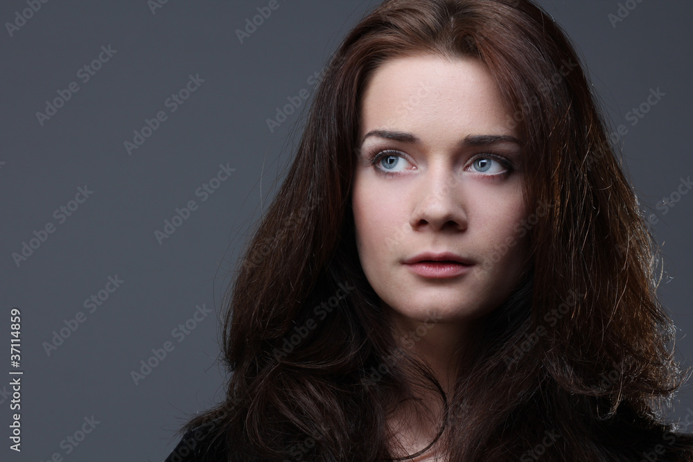 Beautiful young woman in grey background Beautiful young woman in grey background
