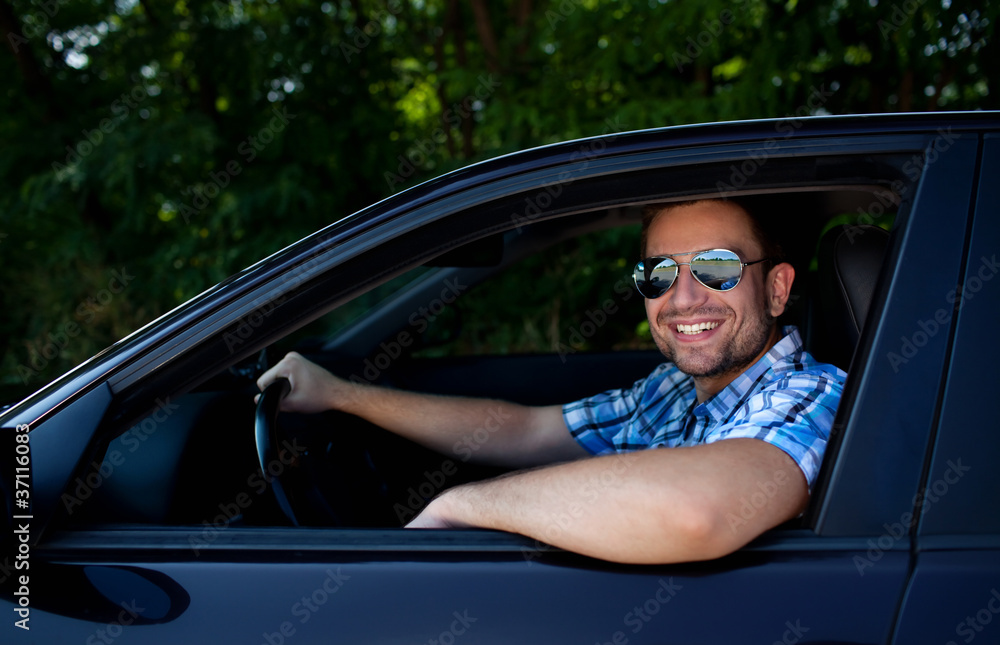 Young man in car smiling