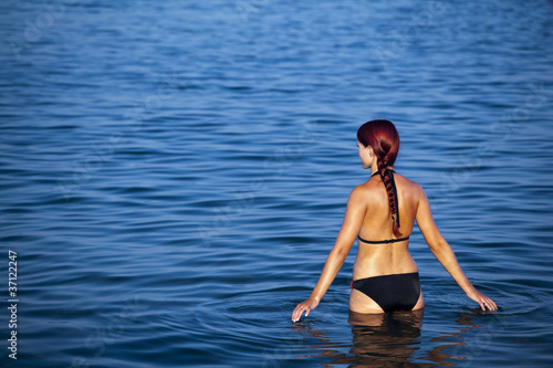 Fototapeta Naklejka Na Ścianę i Meble -  Młoda piękna kobieta w morzu. Greckie wybrzeże - Rhodes.