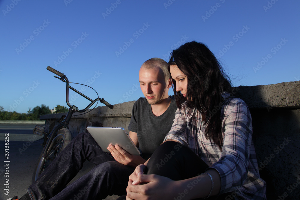 beauty girl and boy with laptop pc outdoors