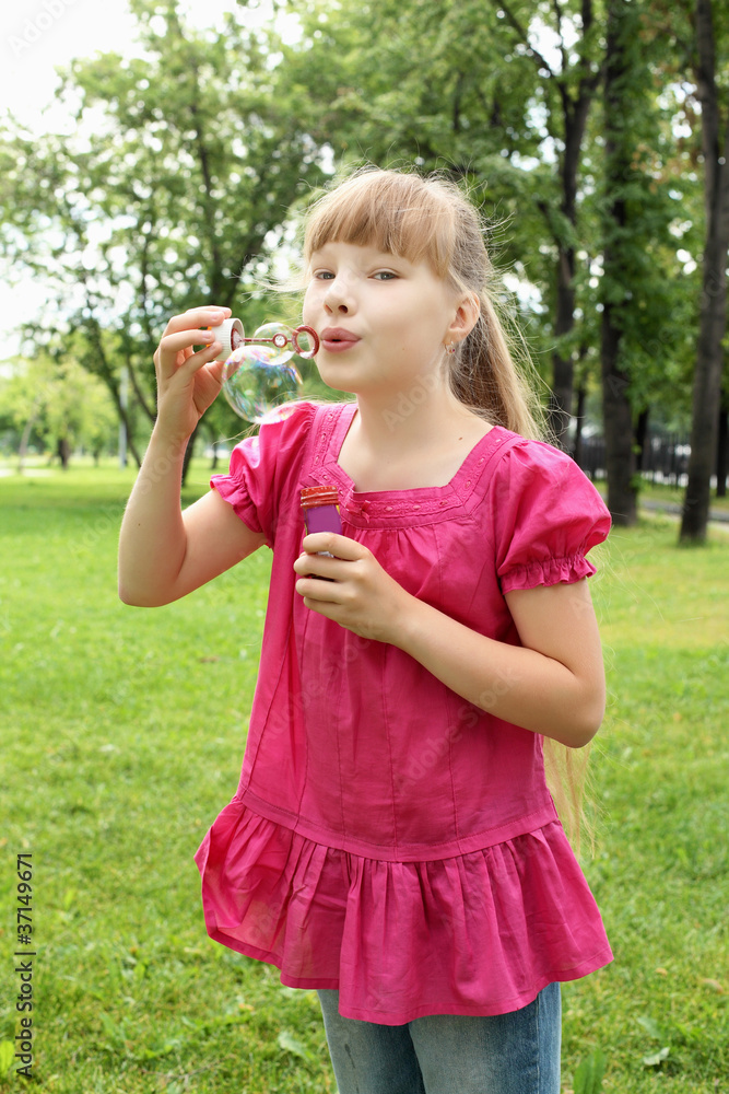 Little girl in the park blowing bubbles Little girl in the park blowing bubbles