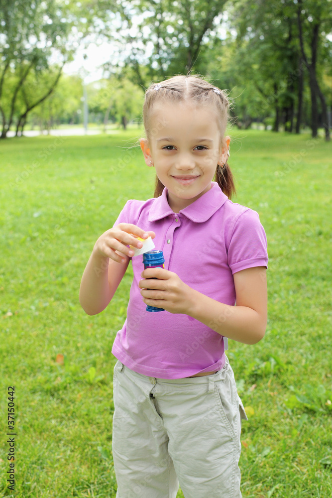 Little girl in the park blowing bubbles Little girl in the park blowing bubbles