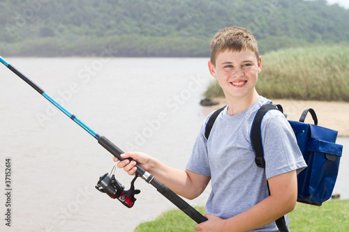 young teenage boy fishing by the lake